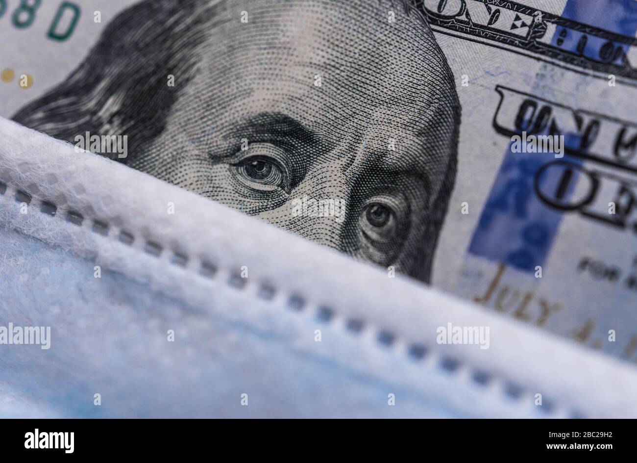 100 US dollars bill with a face mask against coronavirus covid-19 pandemic. Stock Photo