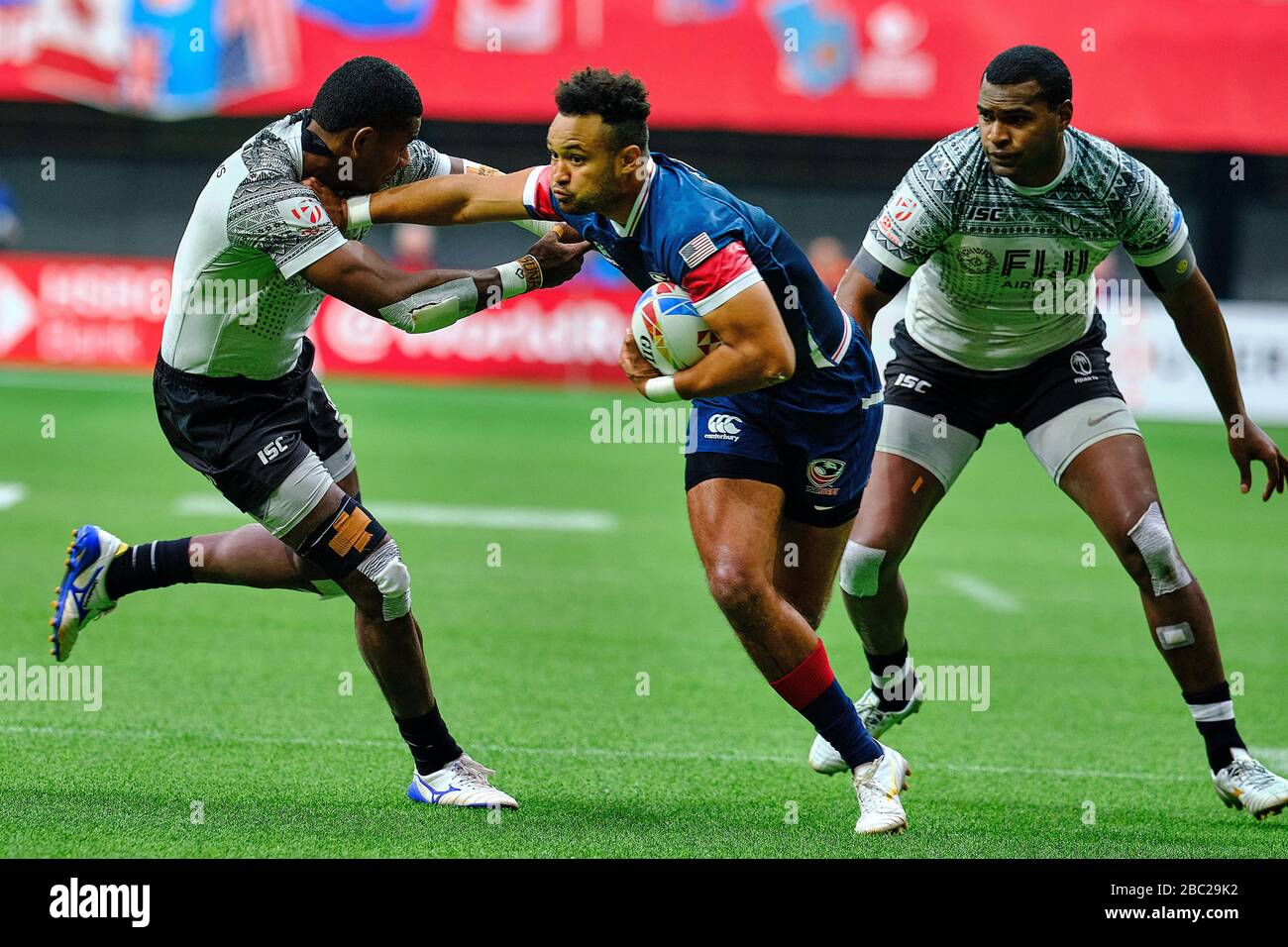 Vancouver, Canada. 8th March, 2020. Maceo Brown #4 of USA tackled by Fiji players in Match #37 (5th Place Semi Final) during Day 2 - 2020 HSBC World R Stock Photo