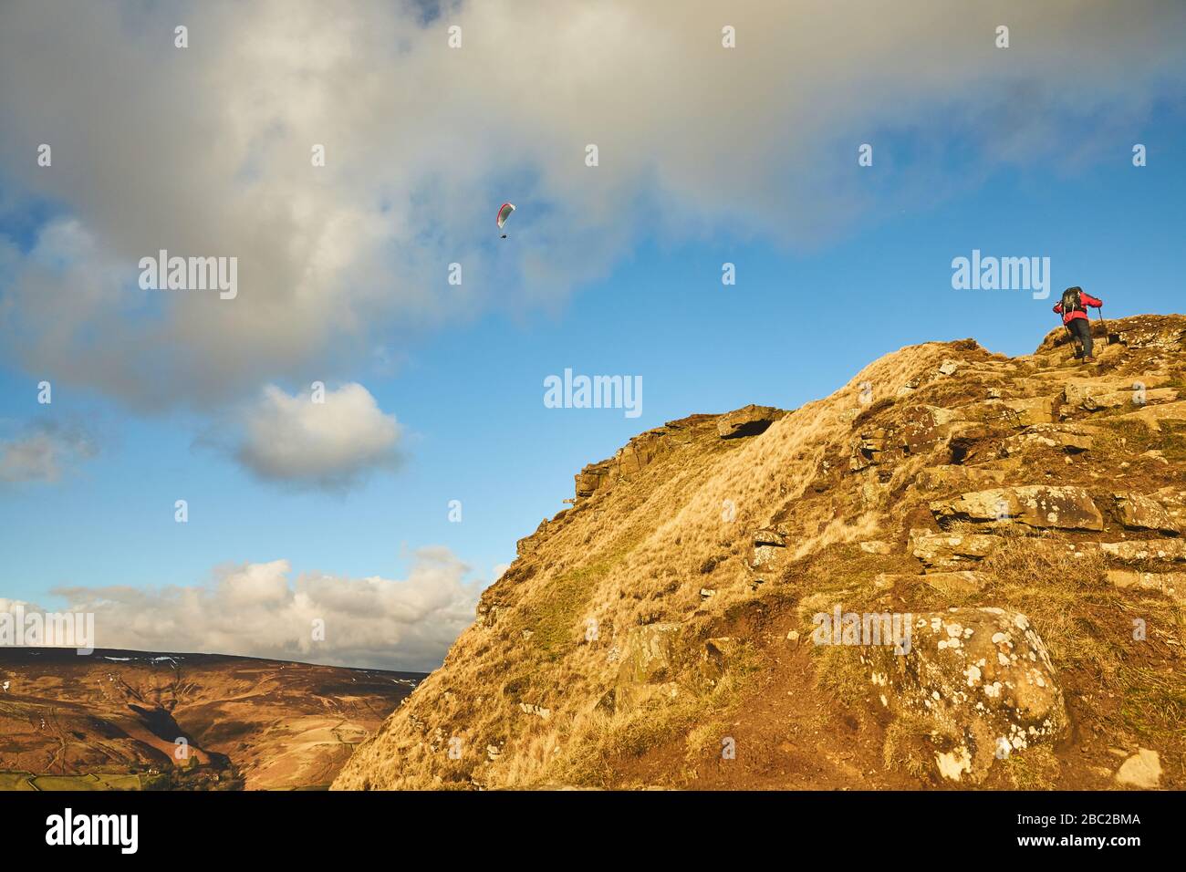 A paraglider and walker on the ridge above Castleton, Peak District. Stock Photo
