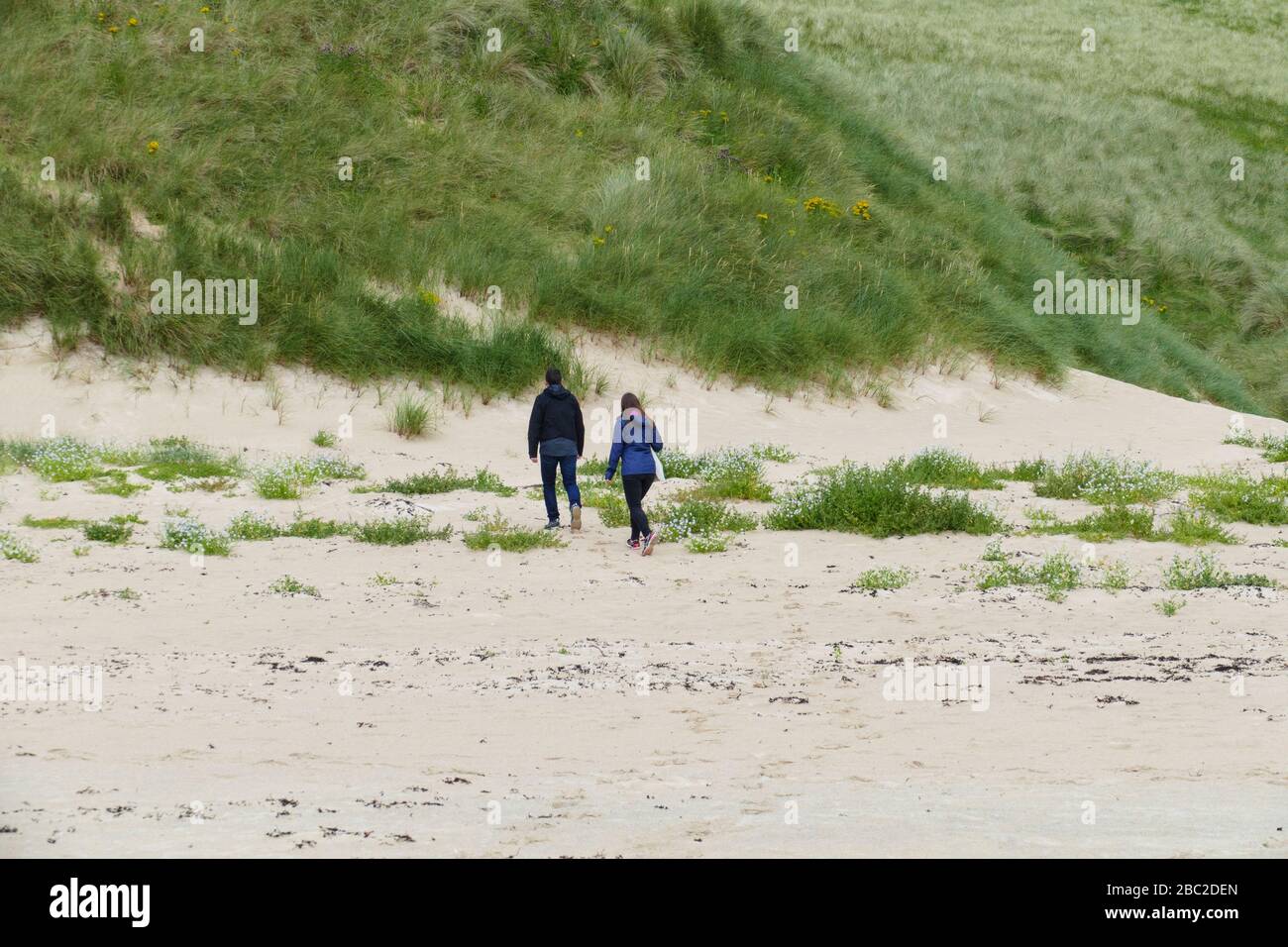 Ein Mann und eine Frau laufen in den Dünen entlang Stock Photo