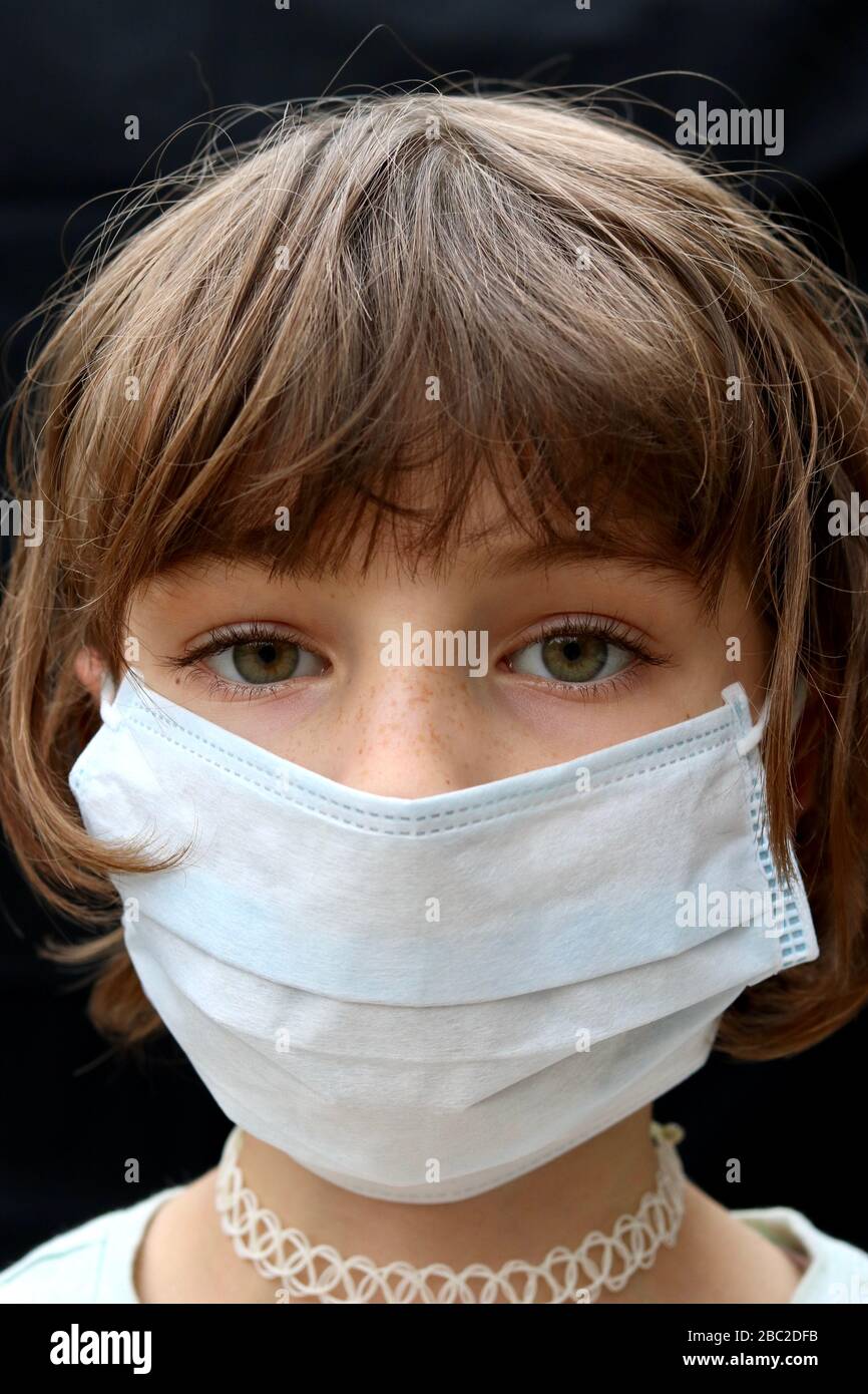 Portrait of young child wearing face mask looking defeated Stock Photo
