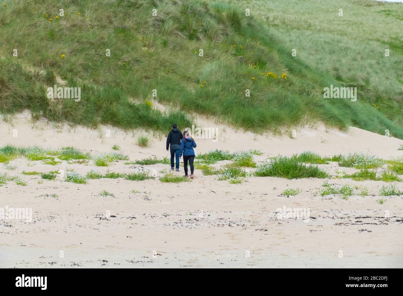 Ein Mann und eine Frau laufen in den Dünen entlang Stock Photo