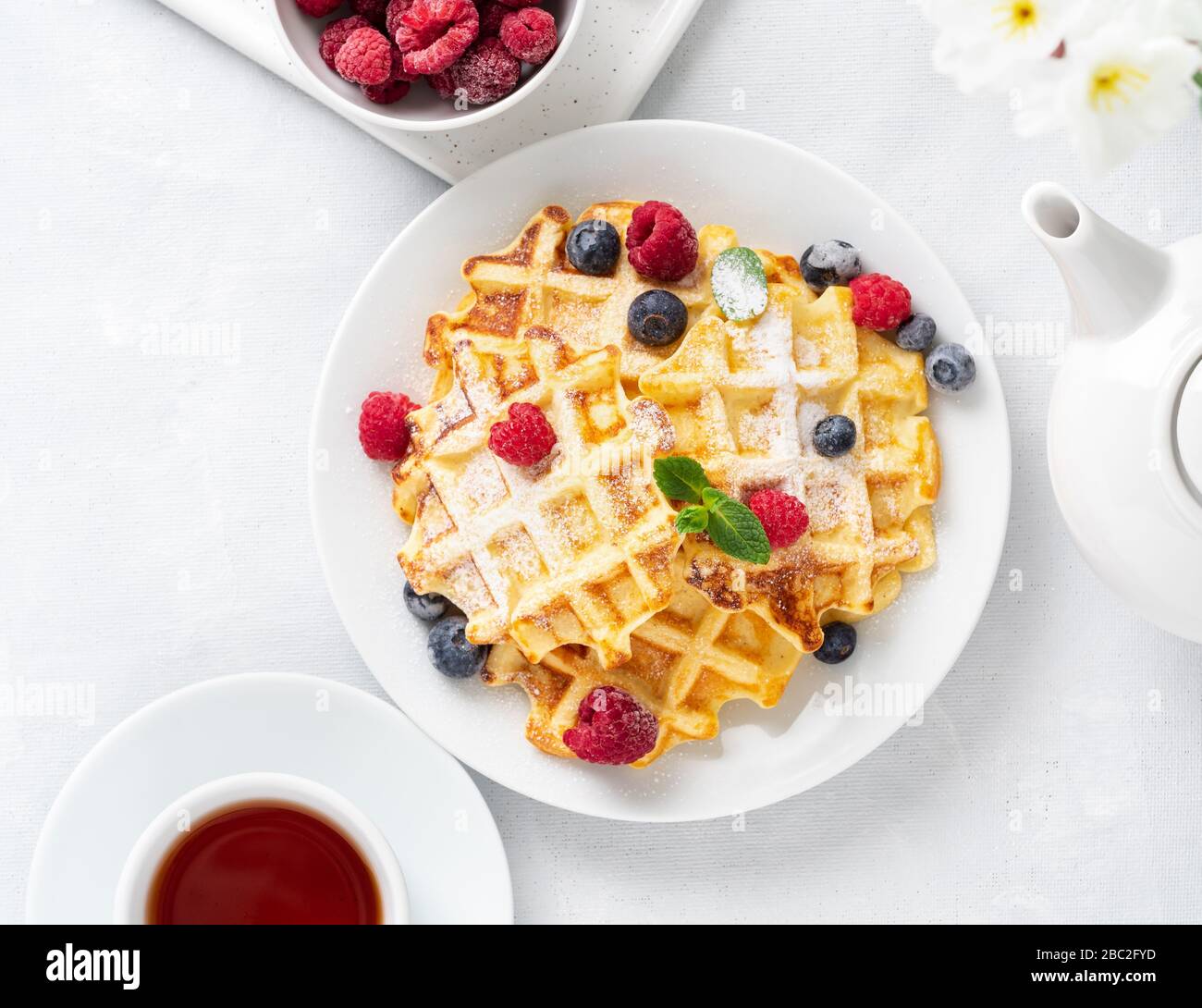 Belgian waffles with raspberries, blueberries, curd and tea, top view. Healthy homemade Stock