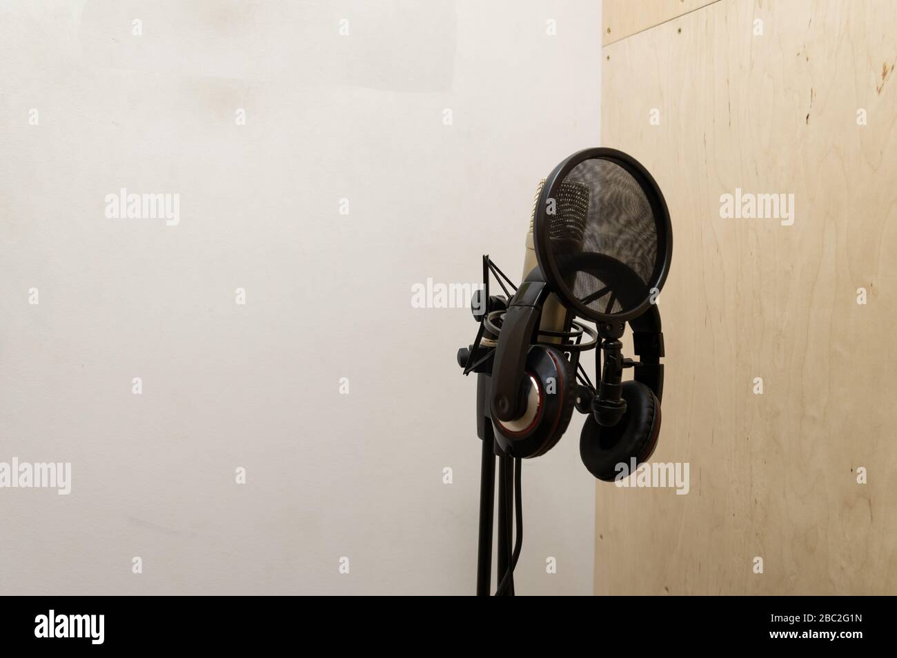 A booth for recording sound. Microphone and headphones for