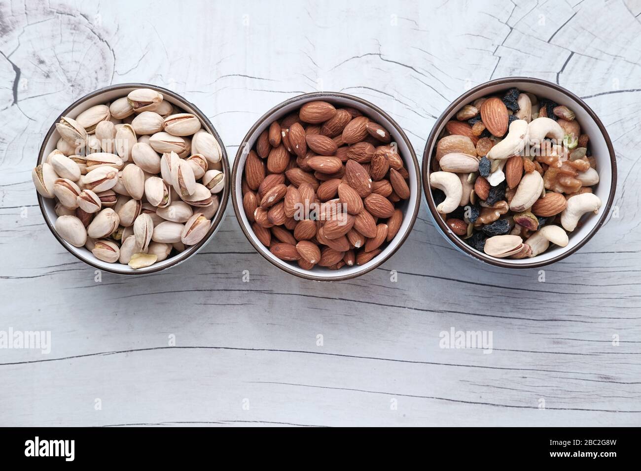 Mixed nuts in wooden bowls on table, top view  Stock Photo