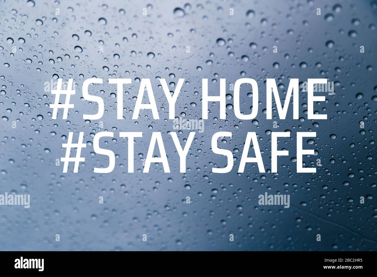 Stay home stay safe concept. Stay at home social media campaign for coronavirus COVID-19 prevention. Close up of rain drops on the window at Stock Photo