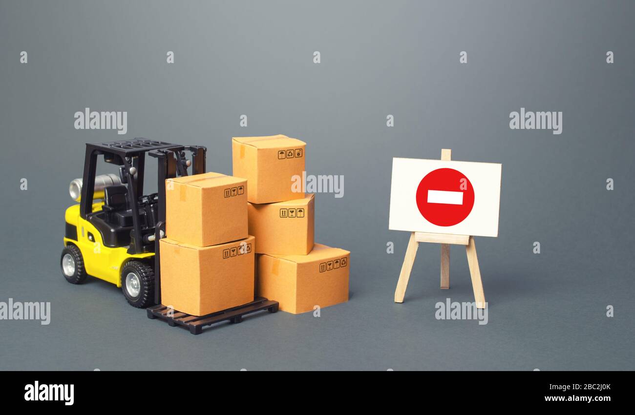 Forklift with boxes and an easel with restriction sign. Restrictions on export of scarce and medical goods for period of border closure quarantine pan Stock Photo