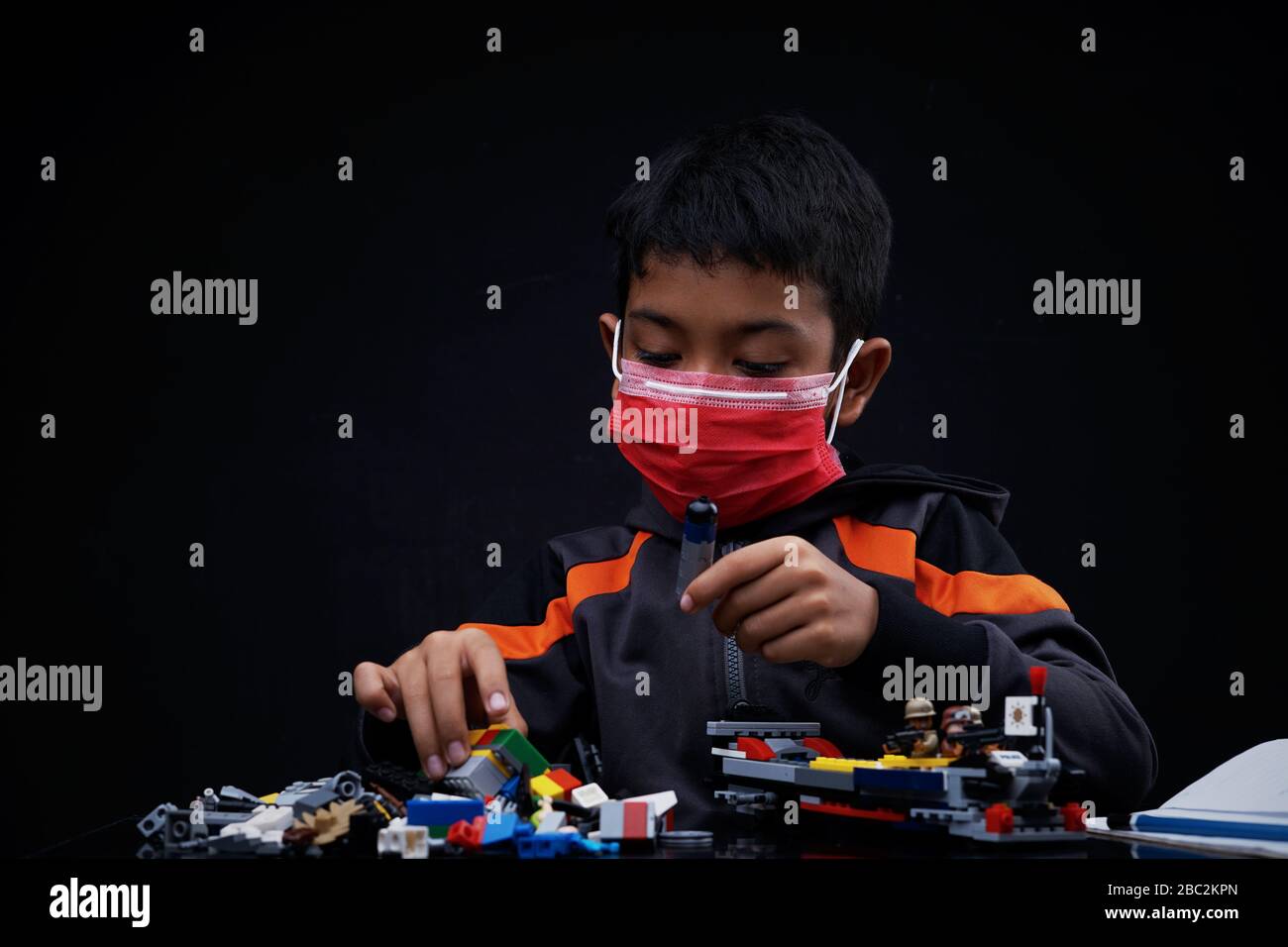 Asian Schoolboy playing and doing his study at home quarantine, Coronavirus Disease Stock Photo