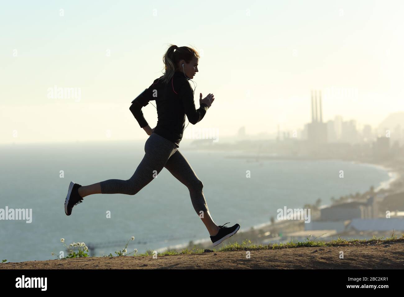 Side view portrait of a silhouette of a runner woman running in city