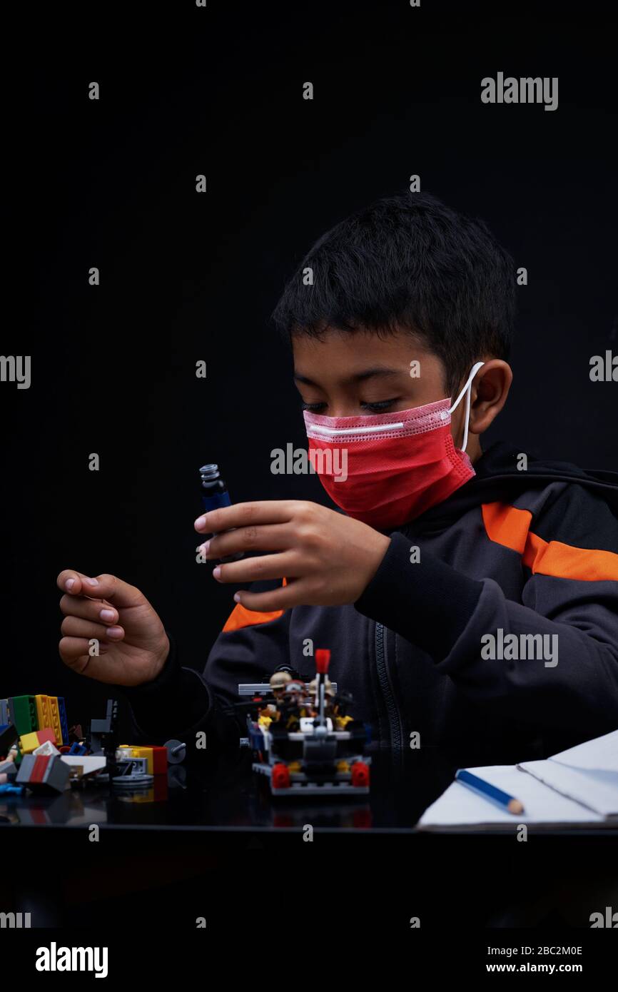 Asian Schoolboy playing and doing his study at home quarantine, Coronavirus Disease Stock Photo