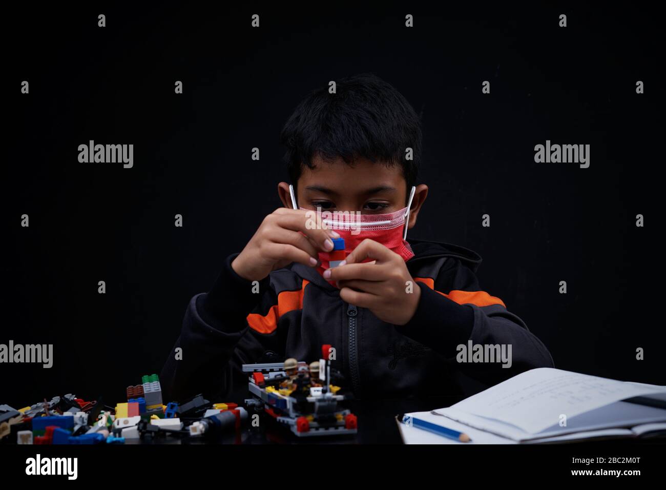 Asian Schoolboy playing and doing his study at home quarantine, Coronavirus Disease Stock Photo