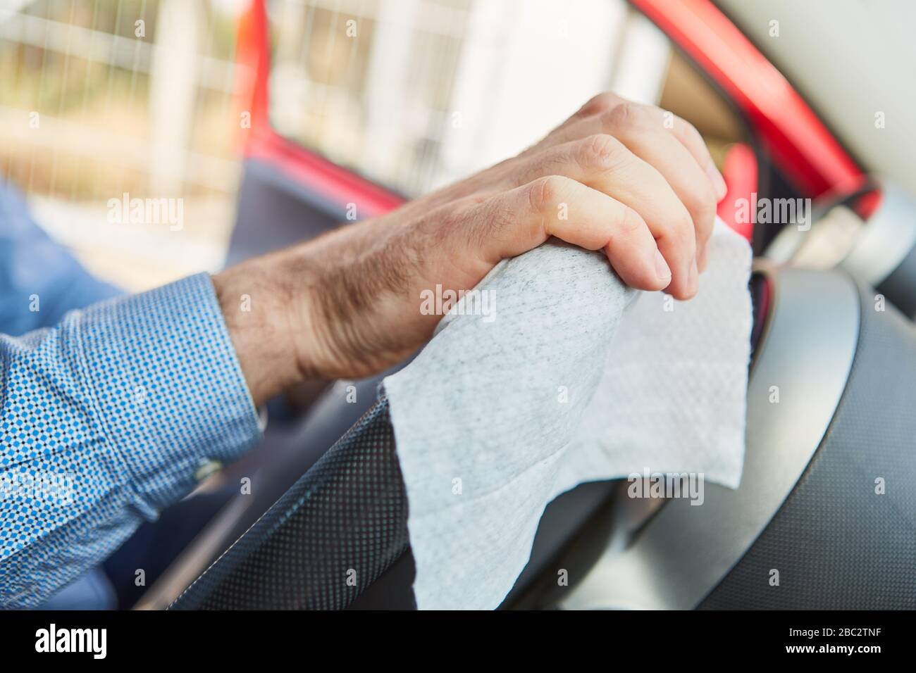 Drivers disinfect steering wheel in rental car from car sharing at