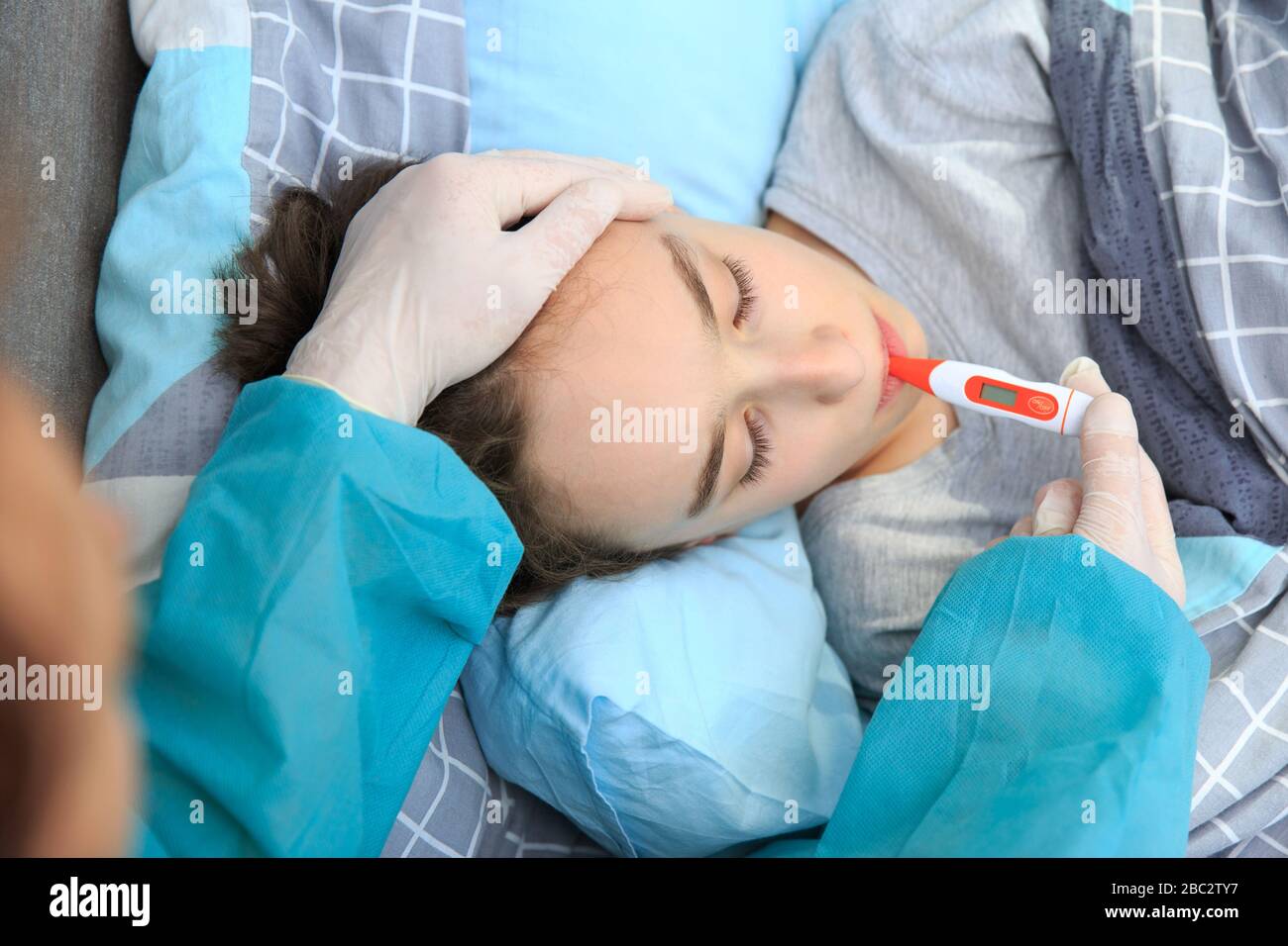 sick kid lying in bed with, Flue and fever , Sick child boy lying in bed with a fever, resting Stock Photo