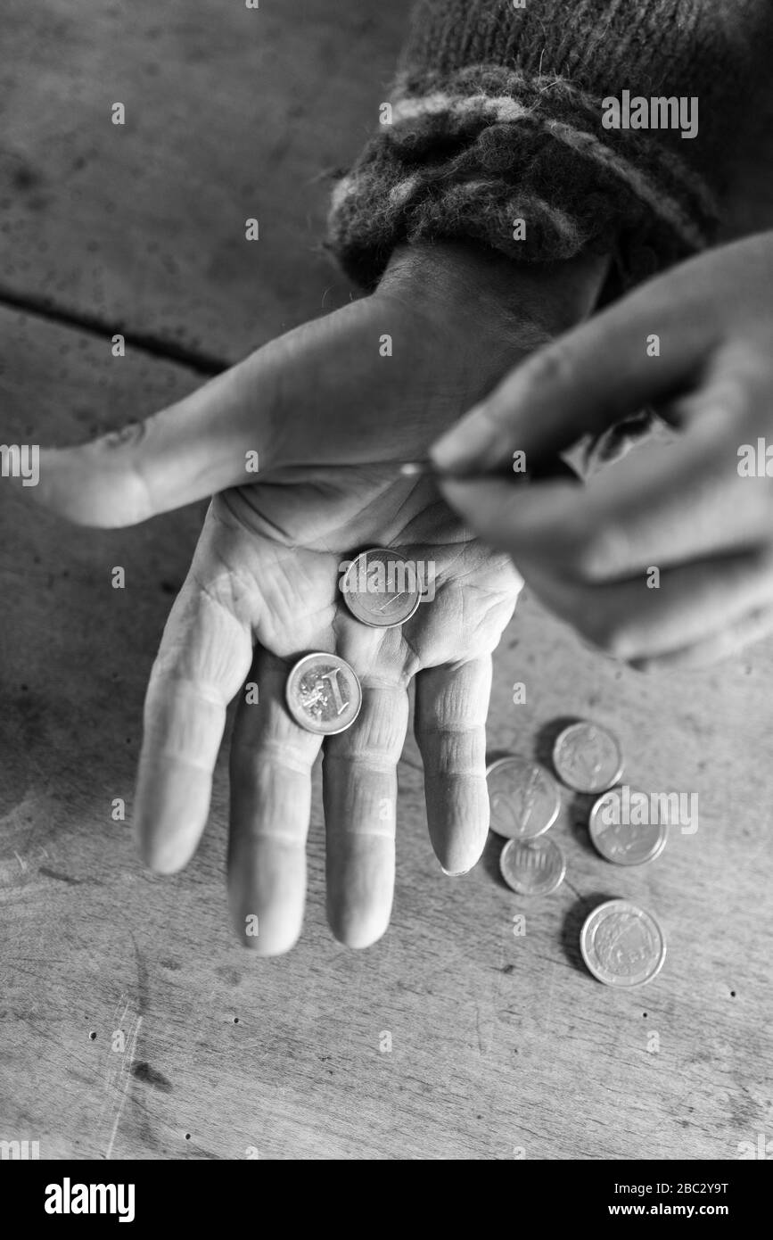 Top view of a palm of senior homeless man with two euro coins in it. Conceptual image of need and poverty. Stock Photo