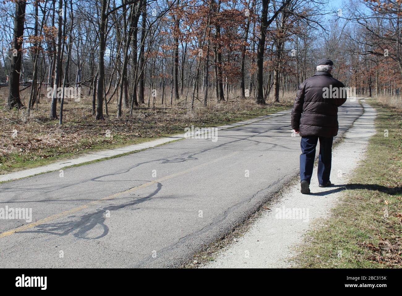 Old Man With A Brown Coat Walking On The North Branch Trail At Miami Woods In Morton Grove 