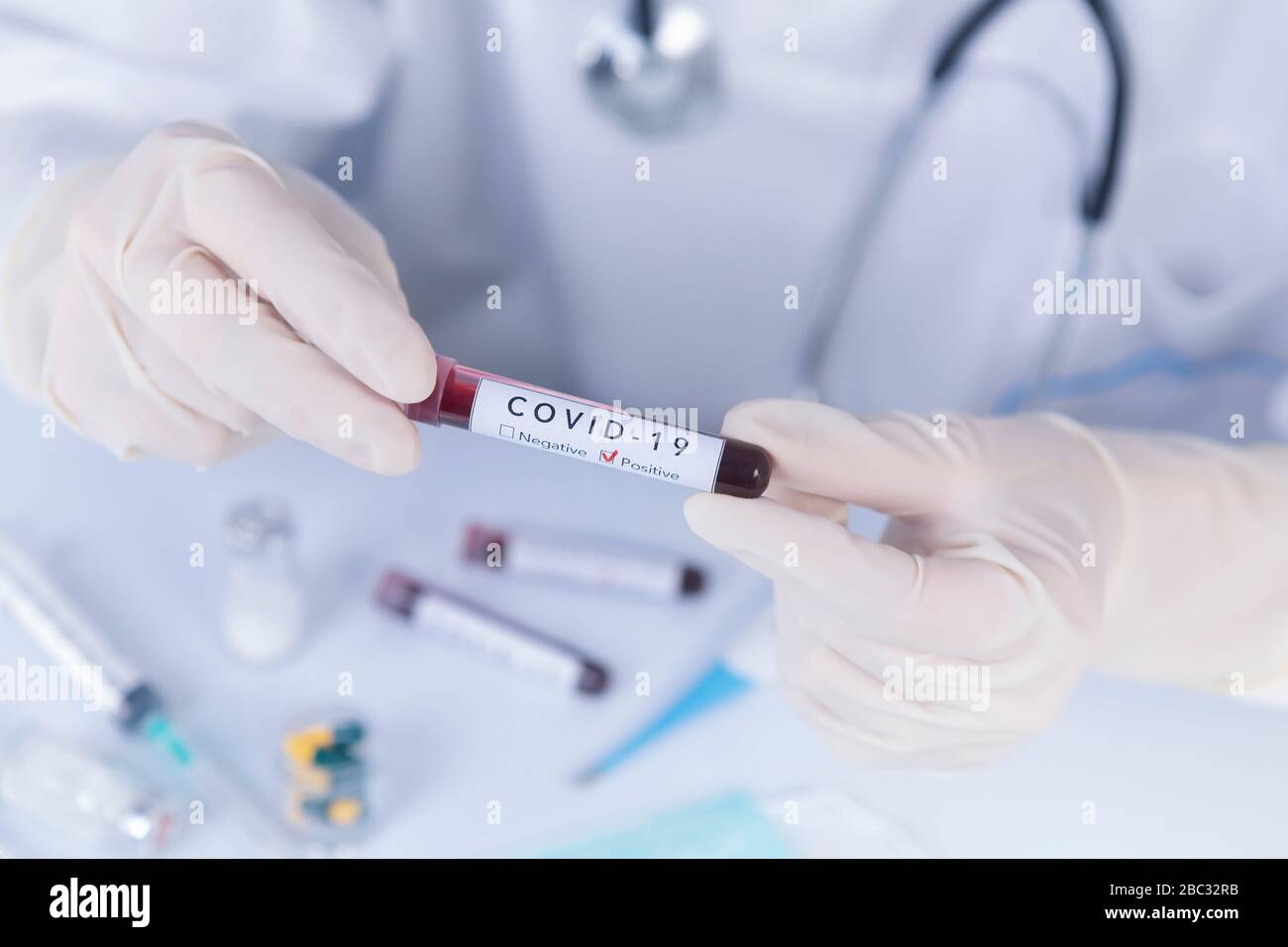 Doctor hands with protective gloves holding COVID 19 Coronavirus test blood. Virus test and research concept Stock Photo