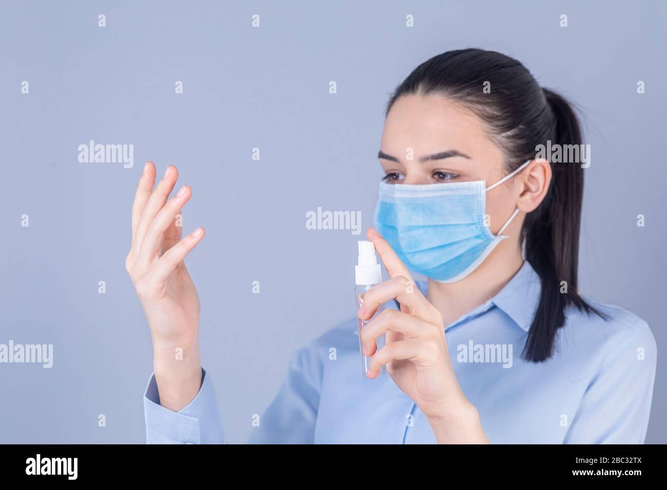 COVID-19 Pandemic Coronavirus. Girl with protective mask holdding alcohol spray cleaning protect disease covid 19. Antiseptic, Hygiene and Healthcare Stock Photo