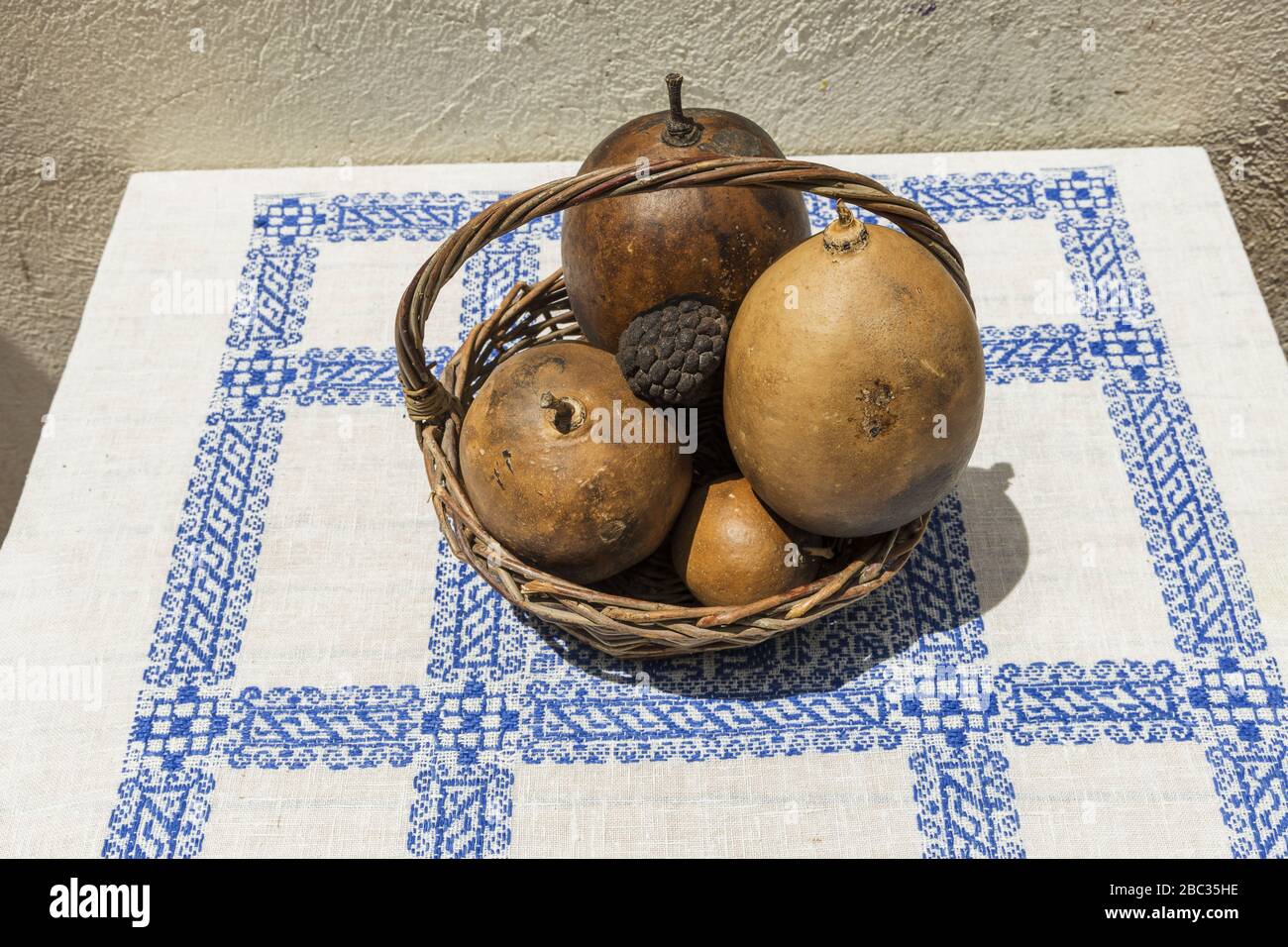 Still life with fruits in wooden basket on table covered with white ...