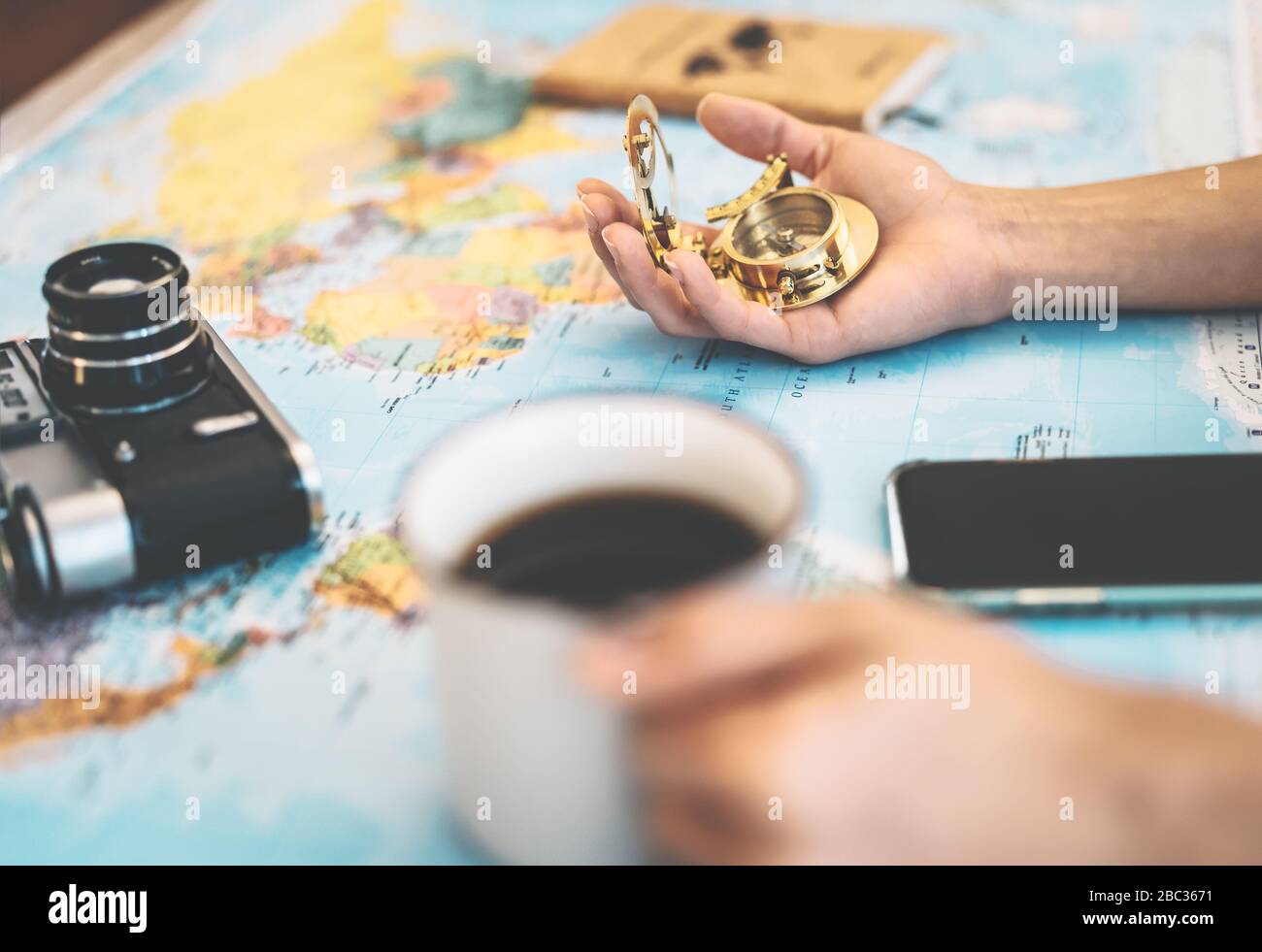 Side view female hands planning vacation with world map and vintage nautical compass Stock Photo