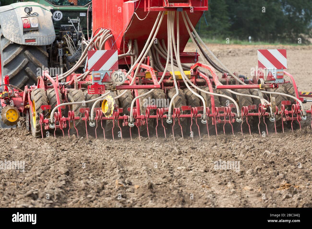 loosen up compacted soil of a agricultural field with a cultivator Stock Photo