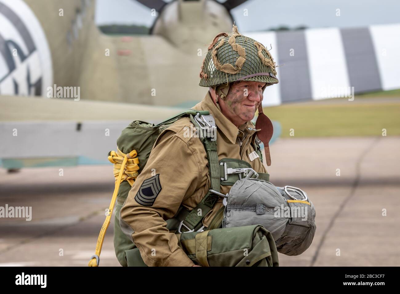 Paratrooper and C-47A Douglas Dakota during the Daks over Normandy event, Duxford Airfield, Cambridgeshire, UK Stock Photo