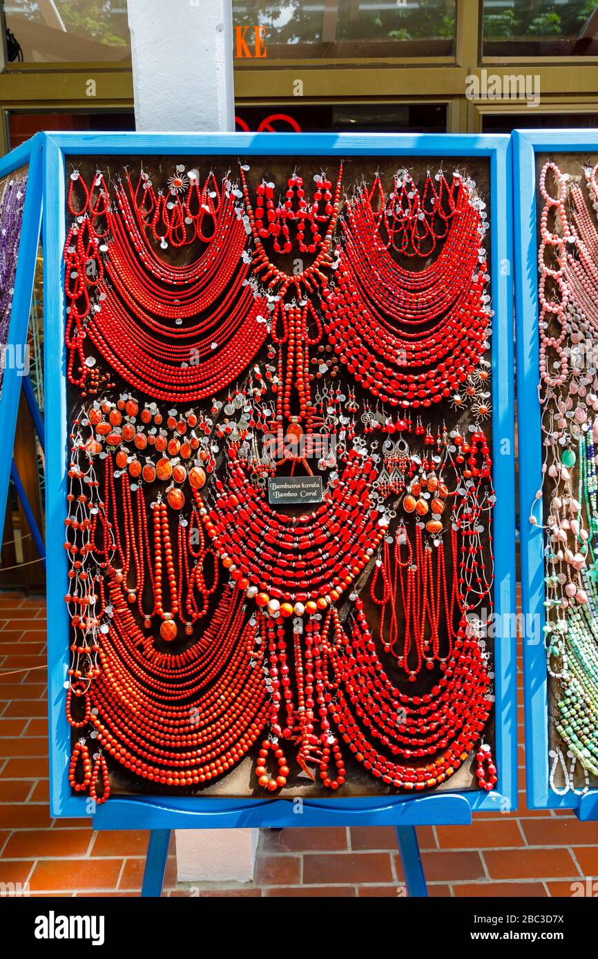 Display of colourful strings of red bamboo coral beads and necklaces in a souvenir shop in Postojnska Jama (Postojna Cave Park), Slovenia Stock Photo