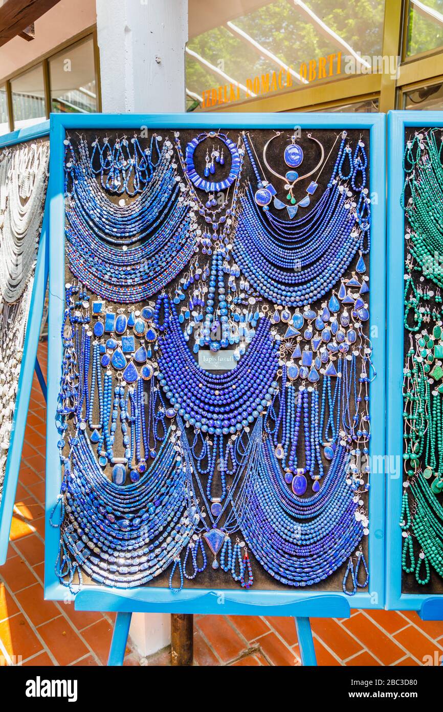 Display of colourful strings of blue lapis lazuli beads and necklaces in a souvenir shop in Postojnska Jama (Postojna Cave Park), Slovenia Stock Photo