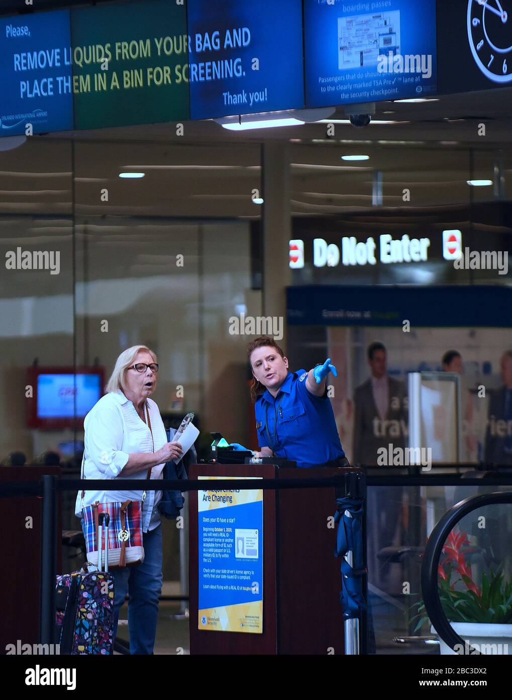 Orlando, United States. 02nd Apr, 2020. April 2, 2020 - Orlando, Florida, United States - A TSA officer wears protective gloves while screening travelers on April 2, 2020 at Orlando International Airport in Orlando, Florida. In the past 14 days across the nation, 58 TSA screening officers have tested positive for COVID-19, including 9 in Orlando. Credit: Paul Hennessy/Alamy Live News Stock Photo