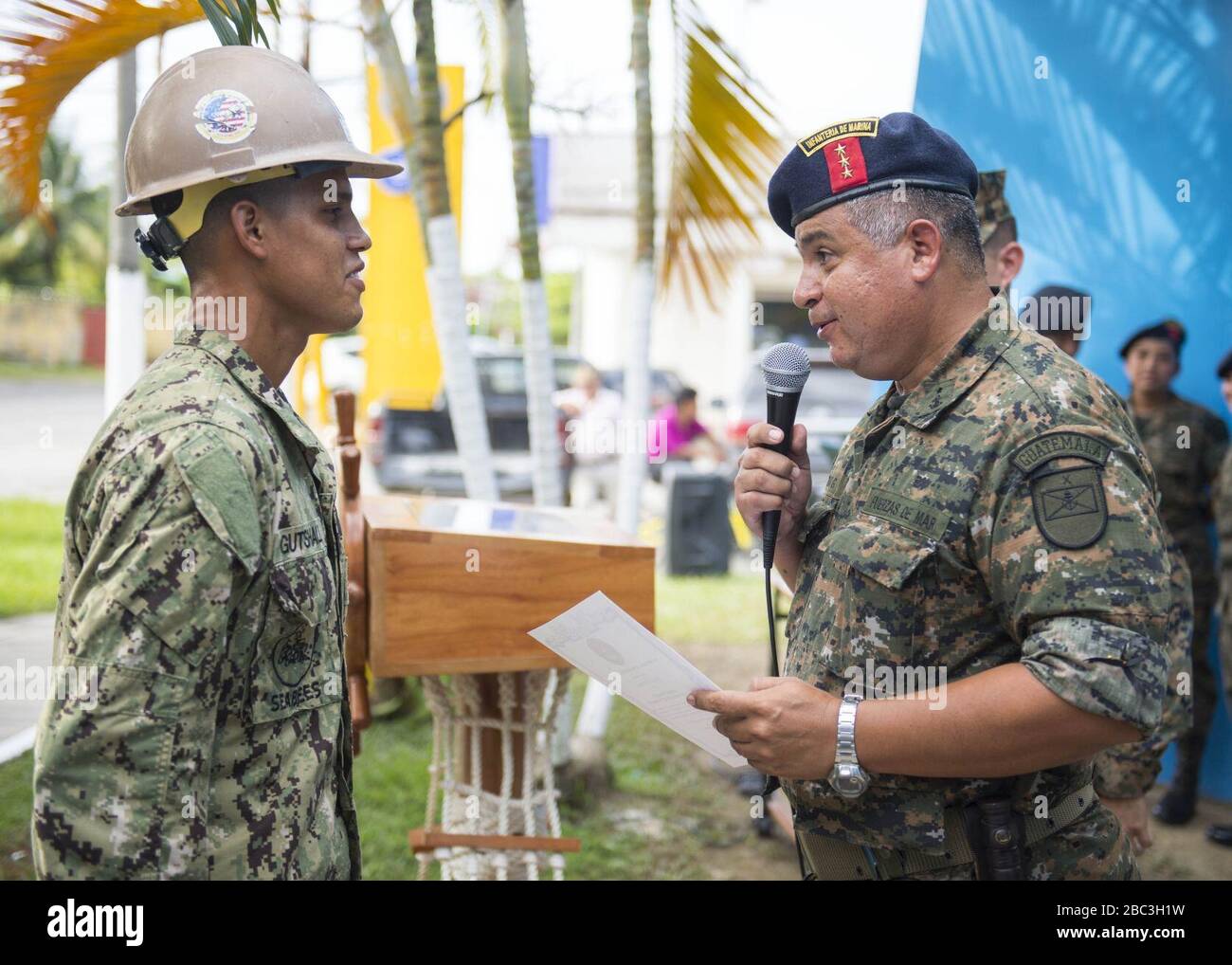 Guatemalan Navy Capt. Saul Arnoldo Tobar Garcia, right, gives a certificate of appreciation to U.S. Navy Builder 2nd Class Jeremy Gutshall, assigned to Construction Battalion Maintenance Unit 202, during 140821 Stock Photo