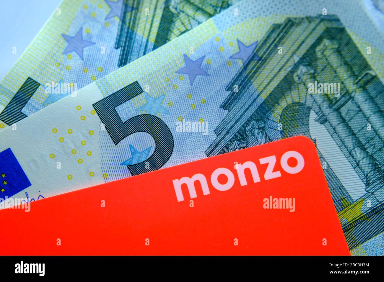 Monzo bank card placed on top of 5 euro bank bill. Close up photo. Stock Photo