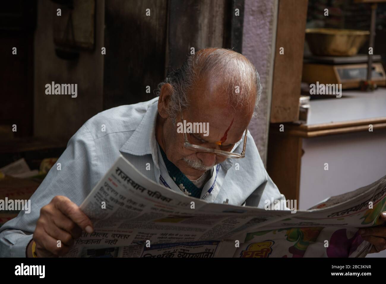 An old man reading newspaper,Jaipur,Rahasthan,India Stock Photo