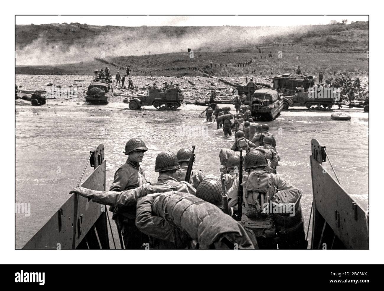 Omaha Beach landng craft D day WW2 American GI Troops disembark D-Day WW2 JUNE 6th 1944 American GI Soldiers group in a landing craft beach under fire by Nazi Wehrmacht gun emplacements at Normandy France during the Allied invasion, June 6, 1944. Along a 50-mile stretch of coastline in northern France, more than 160,000 Allied troops stormed Utah Beach and four other beaches that day to gain a foothold in continental Nazi Europe. By the end of the D-Day invasion, more than 9,000 of those Allied troops were either dead or wounded -- the majority of them Americans. World War II Stock Photo