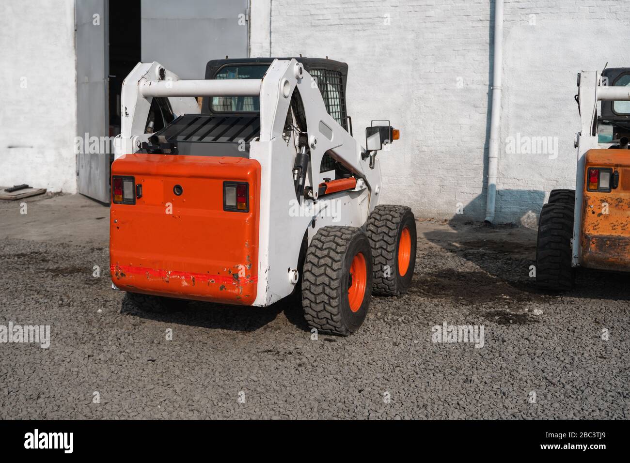White skid steer loader at a construction site waiting of work