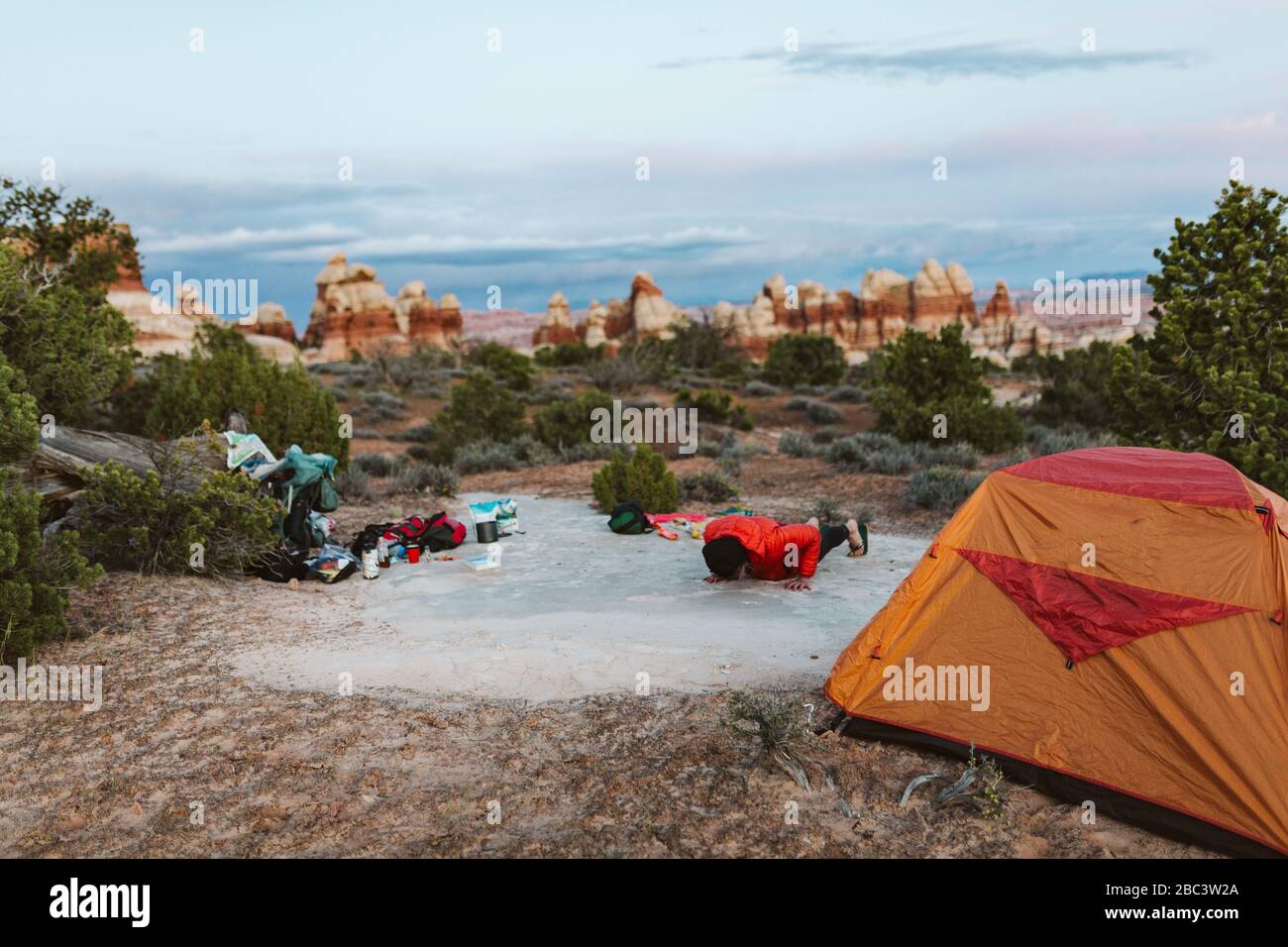 female camper does pushups at her campsite in the desert of utah Stock Photo