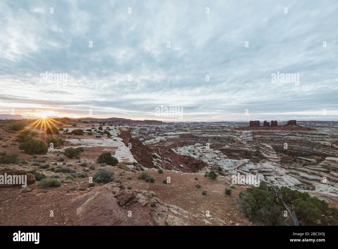 sun rises over a sea of canyons and red rock cliffs of The Maze Utah Stock Photo