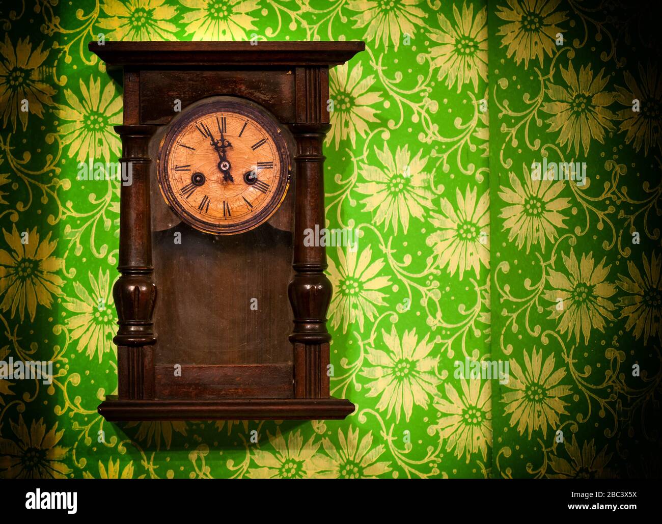 Old vintage wooden wall clock hanging on green wall Stock Photo Alamy