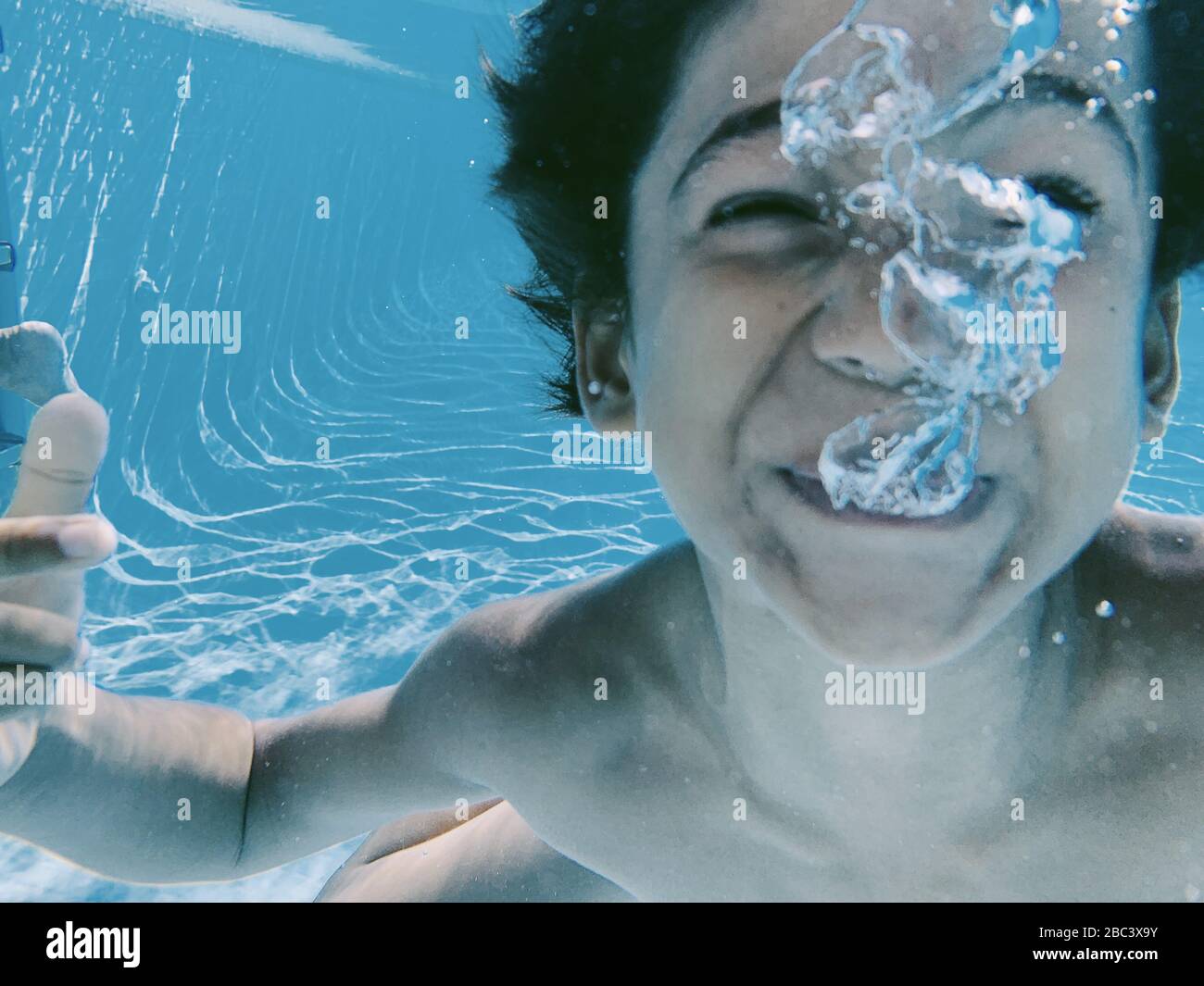 Underwater view of kid playing in a swimming pool