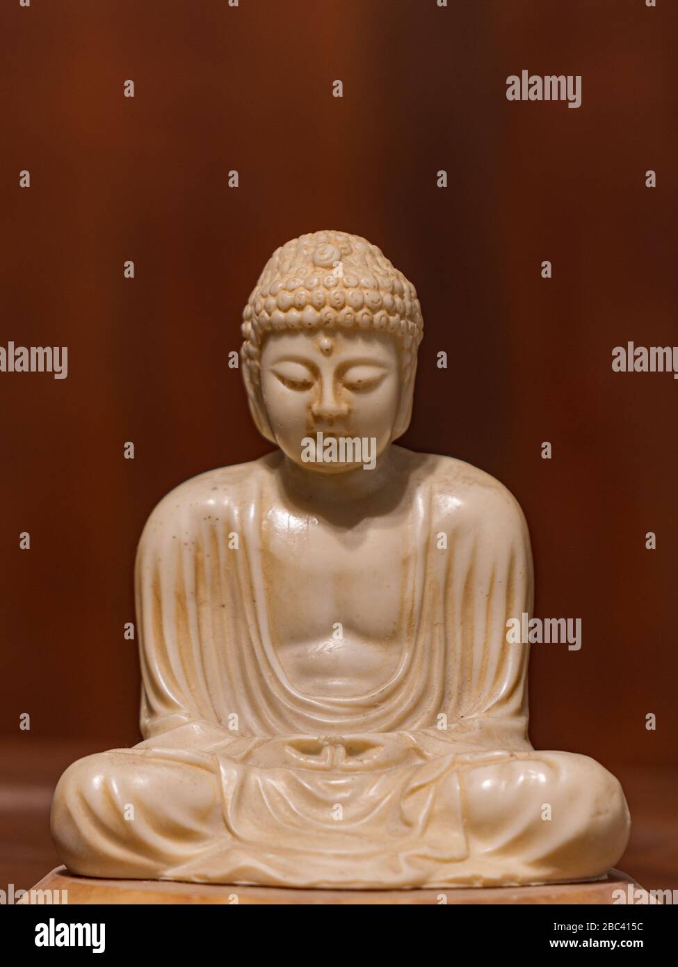 Statuette of Gautama Buddha in light marble in a prayer position, Dhyana-mudrain Buddha Shakyamuni in meditation Stock Photo