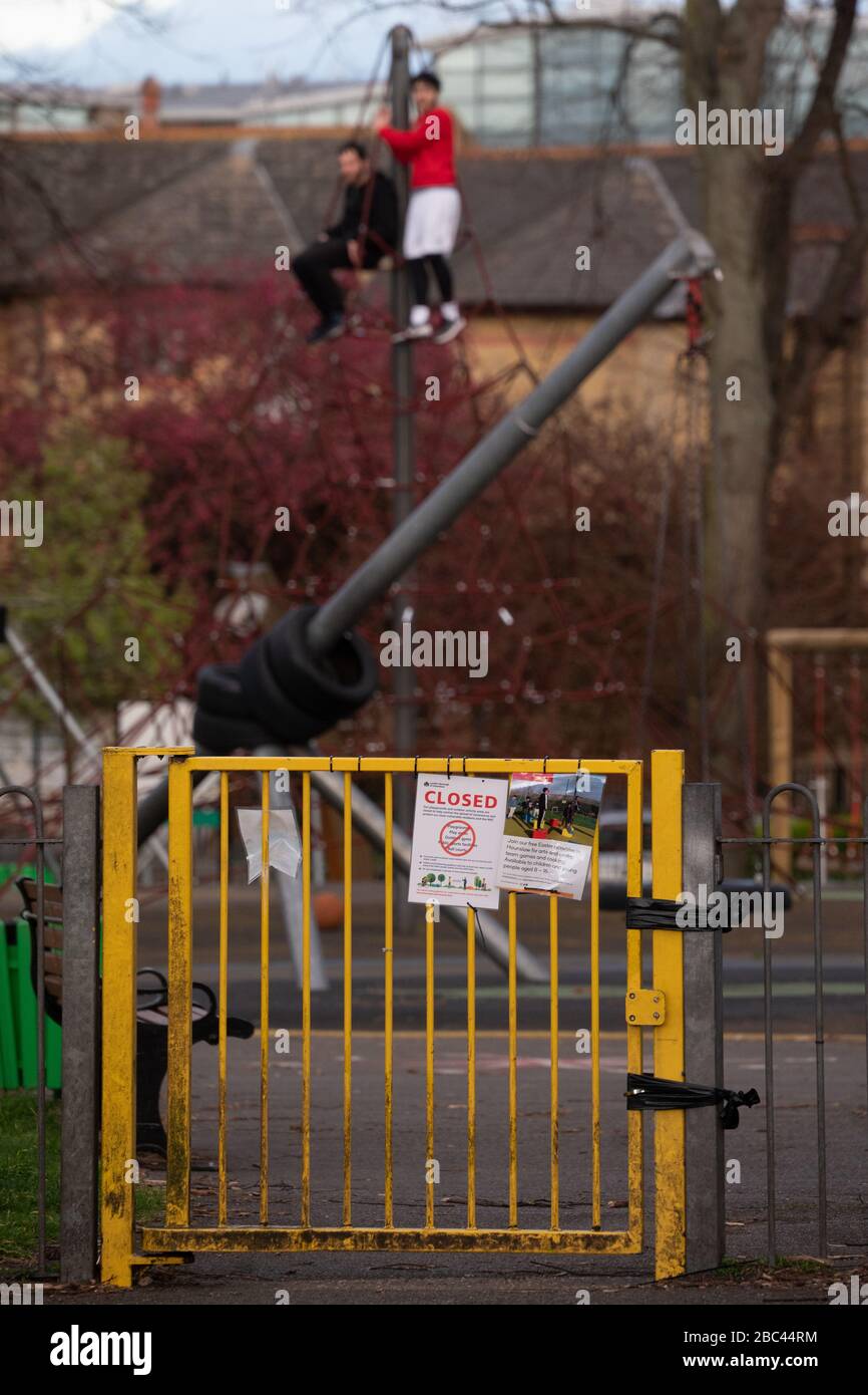 London, UK. Thursday, 2 April, 2020. Scenes from a City in Lockdown: Two men on a climbing frame in the play area of a park, closed due to the coronavirus lockdown. . Photo: Roger Garfield/Alamy Live News Stock Photo
