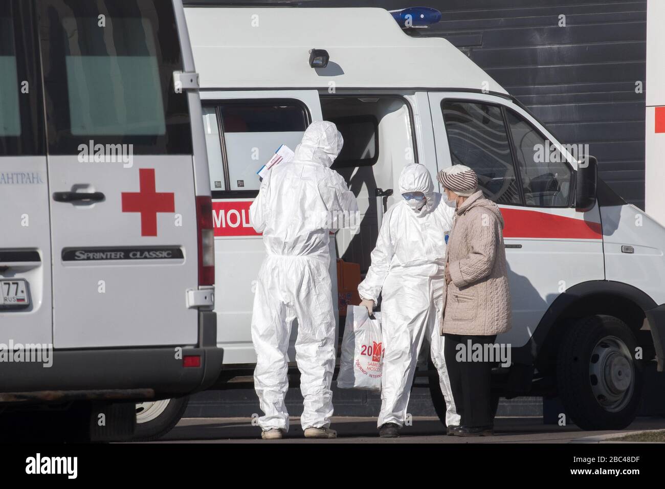 Moscow, Russia. 25th Mar, 2020. Woman wearing a protective mask gets out of an ambulance upon the arrival at Novomoskovskiy multi-speciality medical centre in Kommunarka, Novomoskovskiy Administrative District, region of the New Moscow during the pandemic of the novel coronavirus (COVID-19). The hospital offers treatment to confirmed and potential patients with the COVID-19 infection and acute respiratory viral infection. Stock Photo