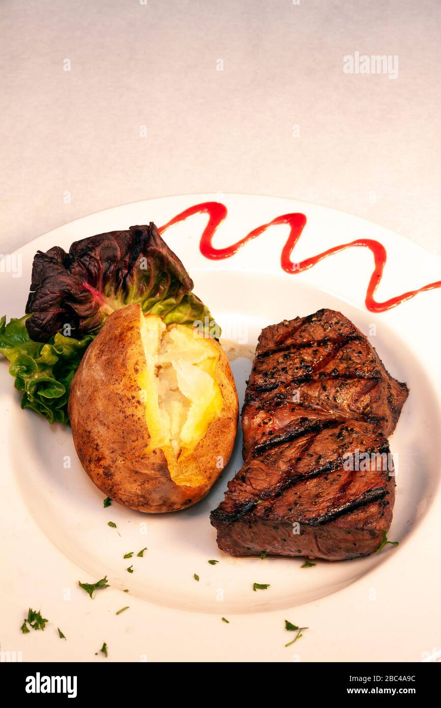 Grilled sirloin steak with baked potato, by James D Coppinger/Dembinsky