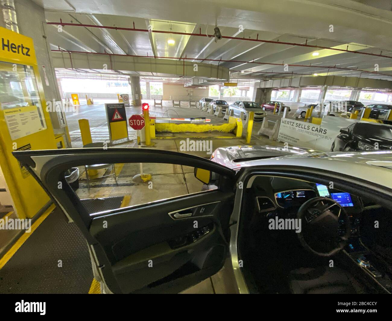 Car exiting the empty car rental area at Hertz´s  Car Rental Parking  area at Miami International Airport Stock Photo