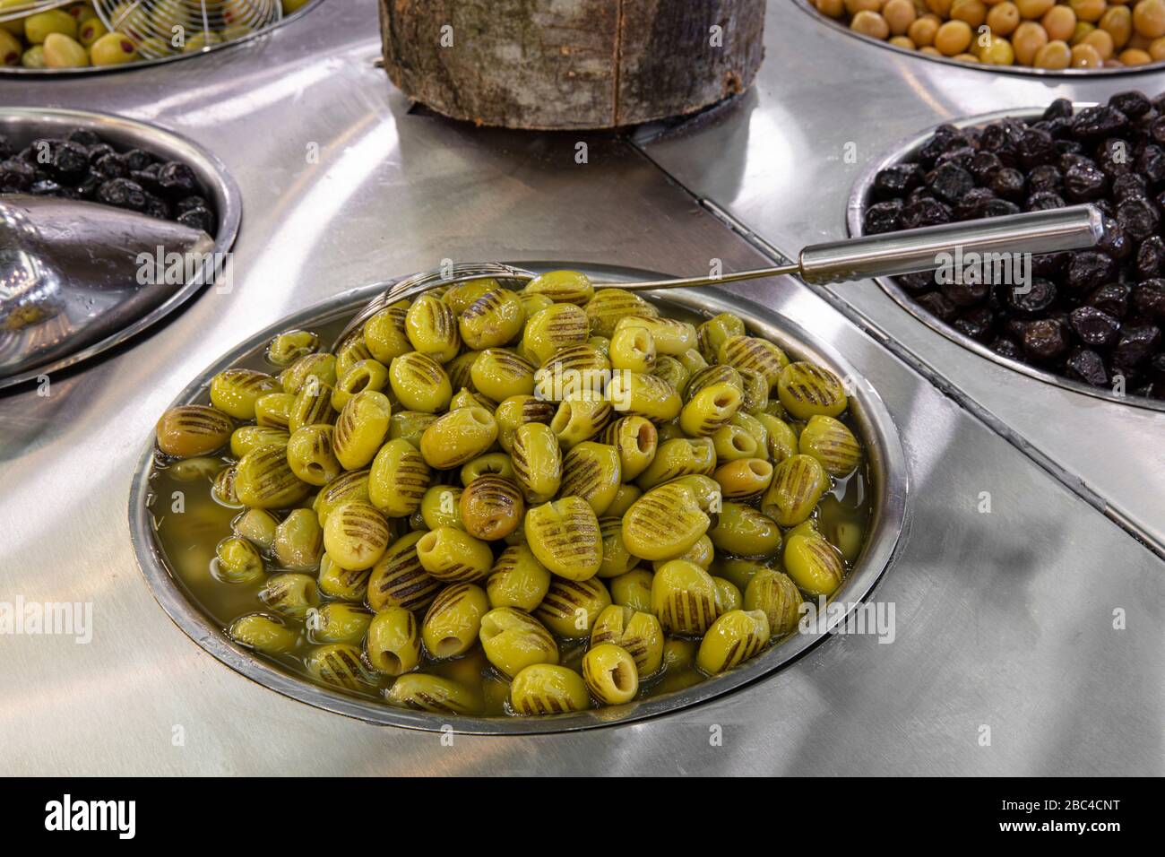 Supermarket olive aisle. Green and black olives in the market Stock