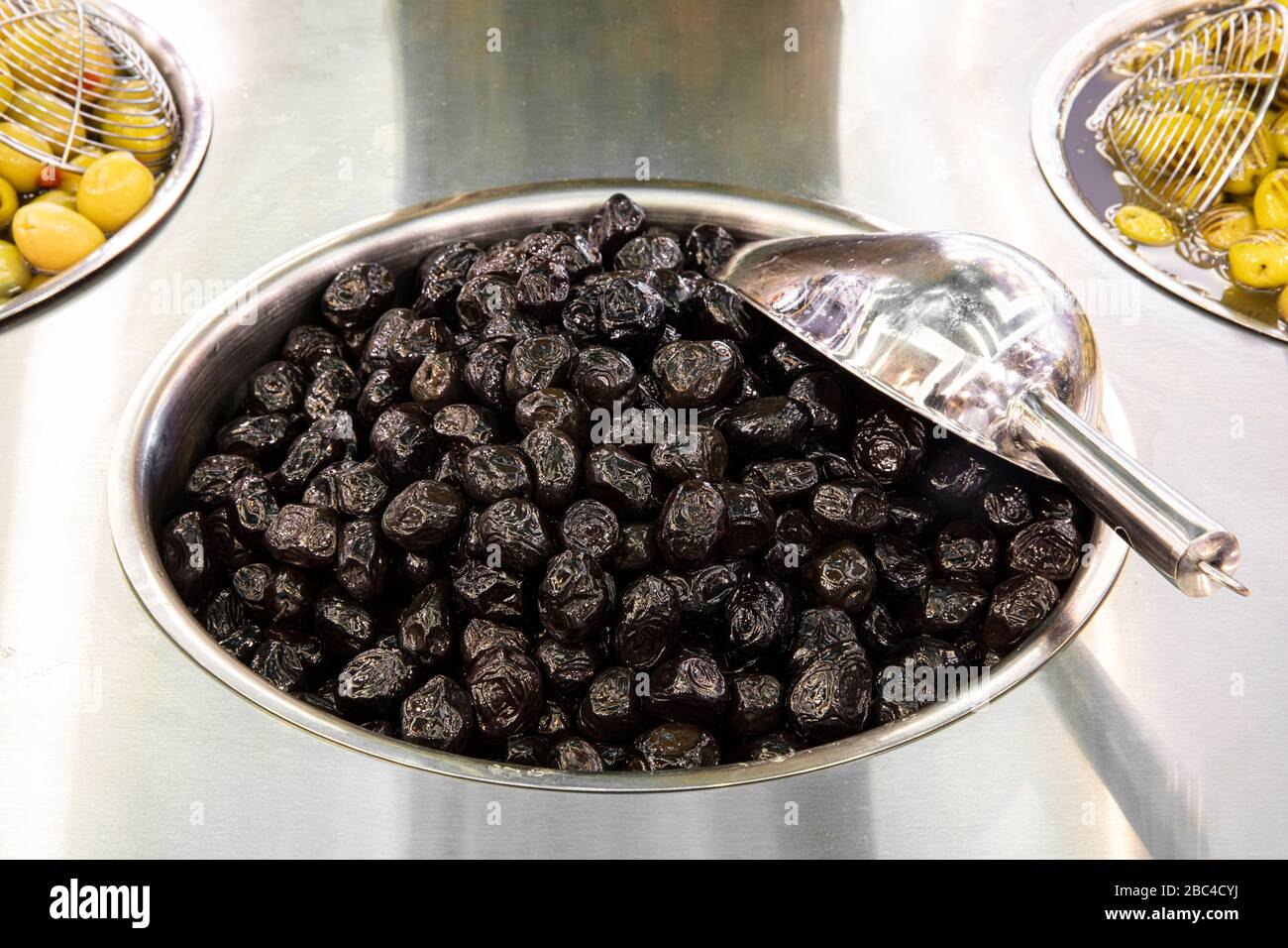Supermarket olive aisle. Green and black olives in the market Stock
