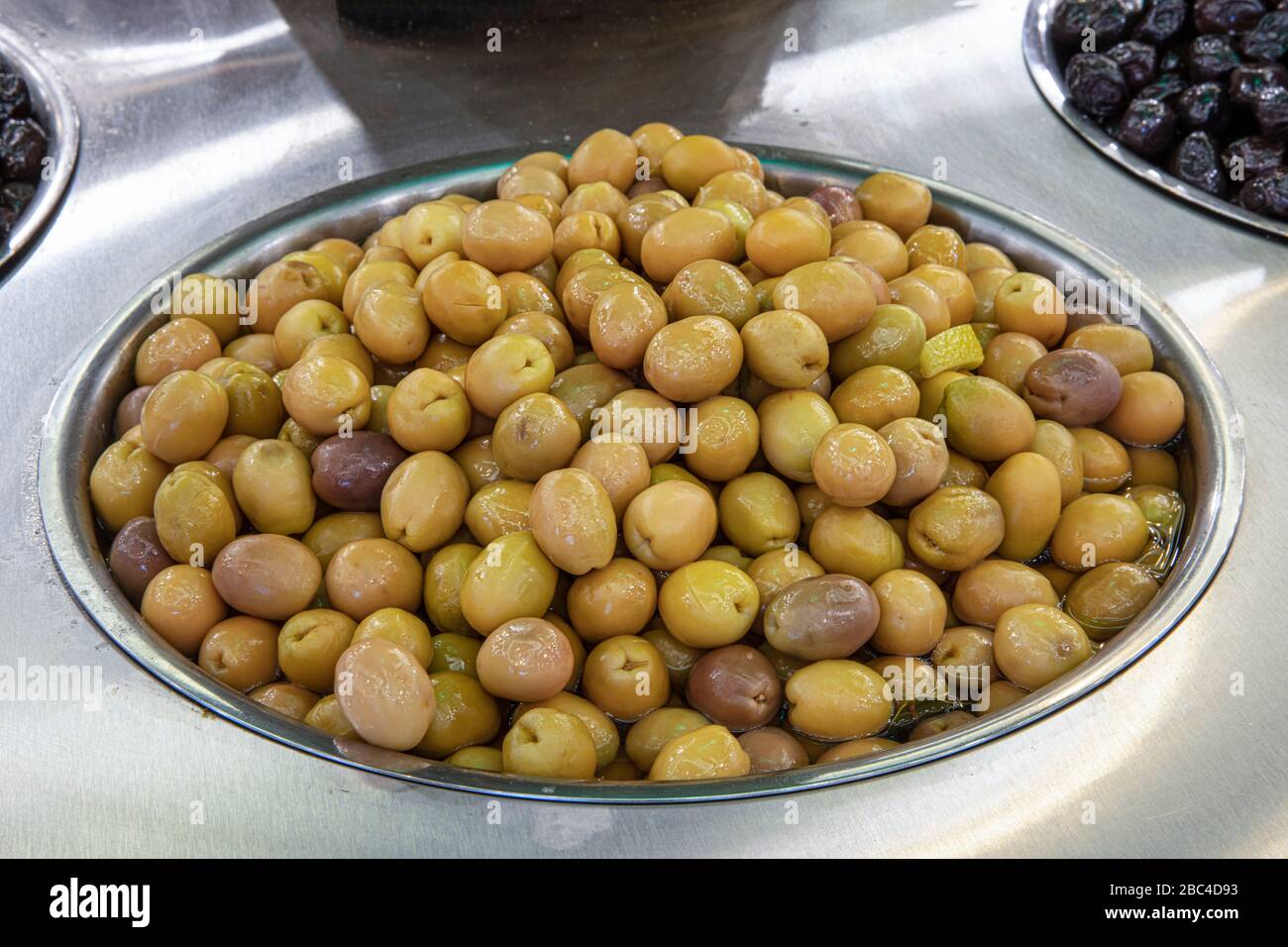 Supermarket olive aisle. Green and black olives in the market Stock