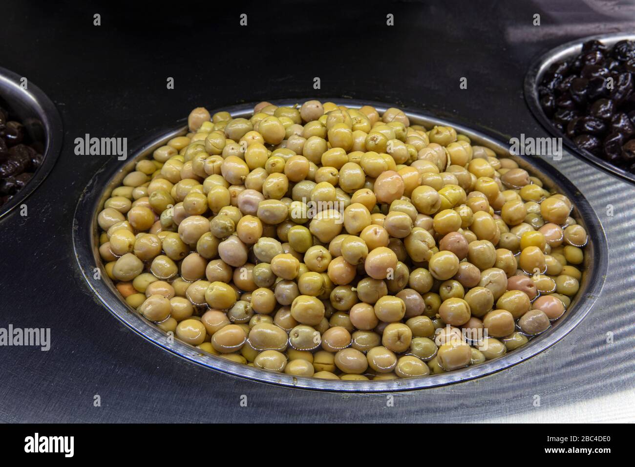 Supermarket olive aisle. Green and black olives in the market Stock