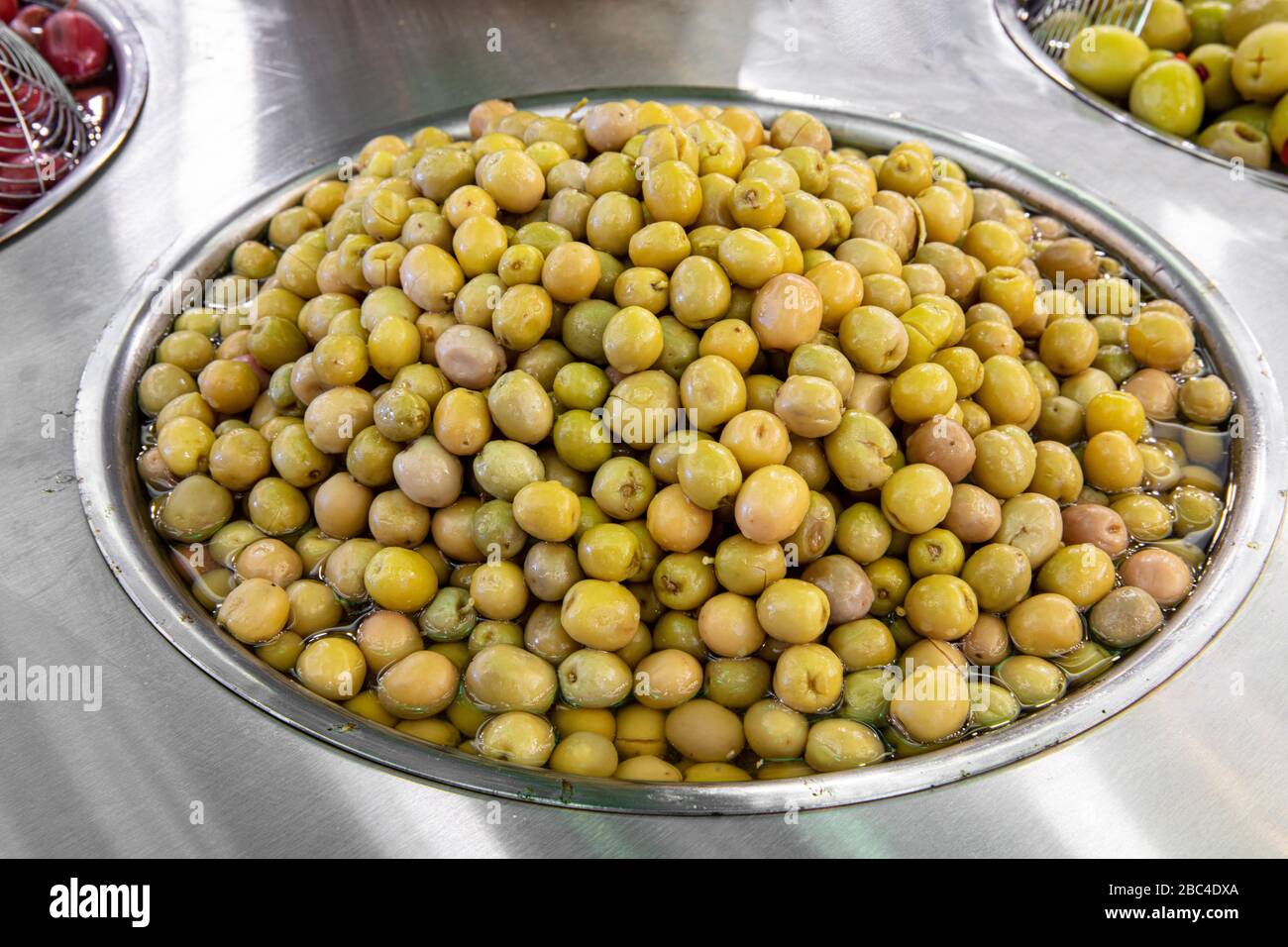 Supermarket olive aisle. Green and black olives in the market Stock