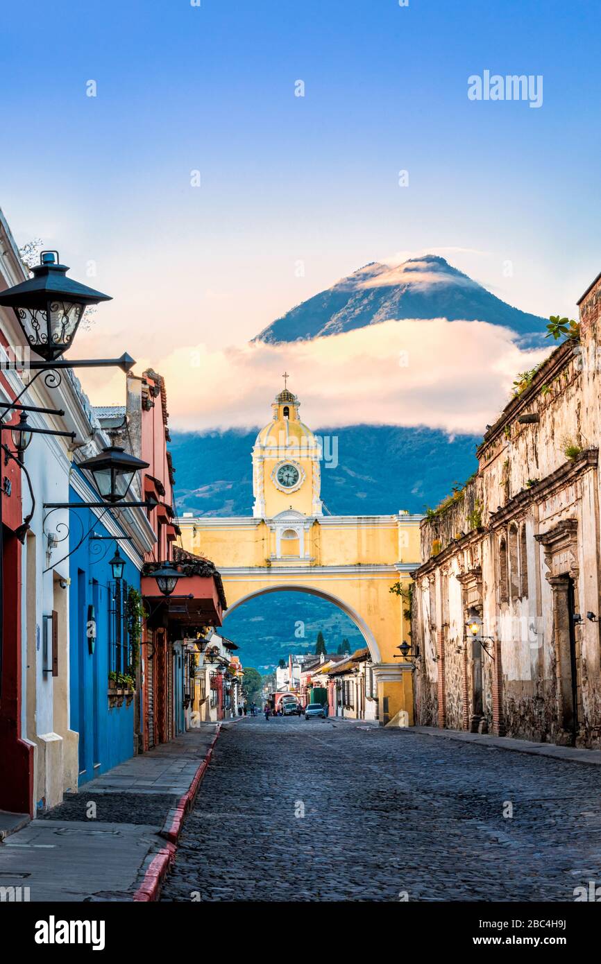 The iconic Santa Catalina Arch in Antigua, Guatemala with the Agua Volcano in the background. Stock Photo