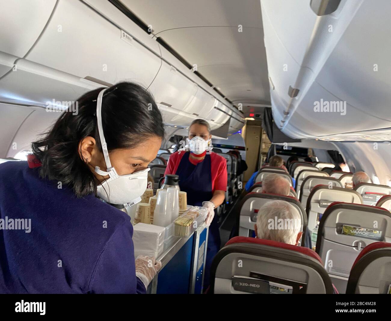 LATAM air attendants use protective gear. As countries and airports shut down, airlines fly trapped passengers on empty flights before closing operations amid an outbreak of the new corona virus COVID-19. The World Health Organization (WHO) declared COVID-19 a pandemic, globally widespread on March 11. Stock Photo