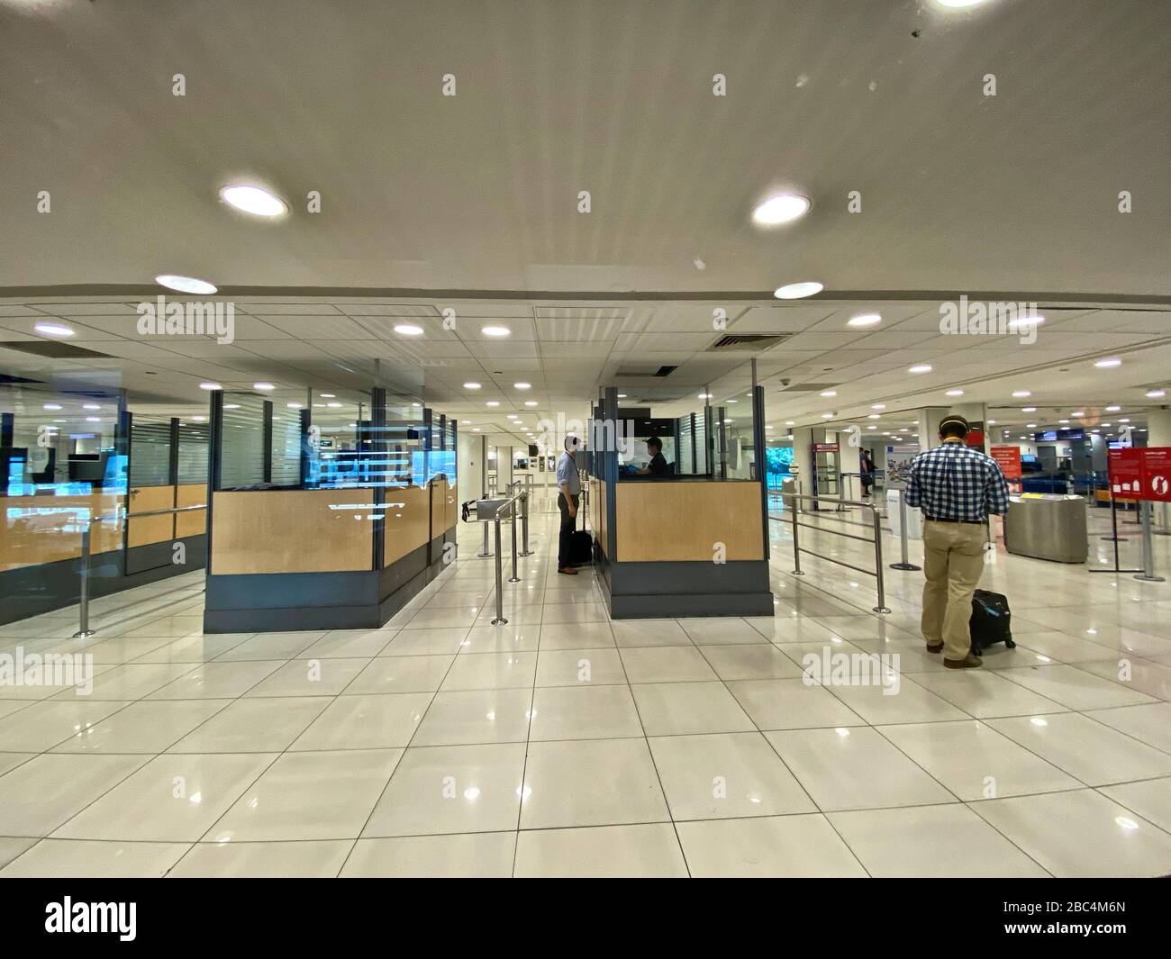 Travelers arrive to empty immigration controls at Santiago International Airport amid an outbreak of the new corona virus COVID-19. The World Health Organization (WHO) declared COVID-19 a pandemic, globally widespread on March 11. Stock Photo